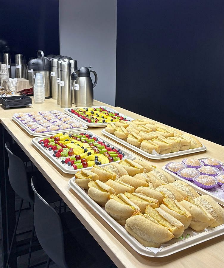 Mesa de coffee break con bocadillos, fruta y dulces para empresas