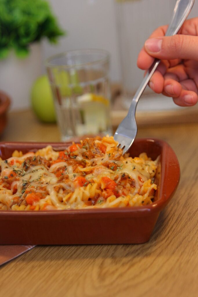 Pasta gratinada con carne y verduras preparada para catering en Valencia